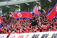 北朝鮮の応援団は終始息の合った歌で選手を鼓舞した。写真●茂木あきら（サッカーダイジェスト写真部）